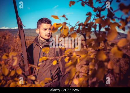 Herbstjagd. Jäger in Tarnkleidung bereit, mit Jagdgewehr zu jagen. Stockfoto