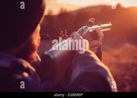 Nahaufnahme Scharfschützen Karabiner bei der Outdoor-Jagd. Rifle Hunter im wunderschönen Sonnenuntergang. Herbstjagd. Verfolgen. Stockfoto