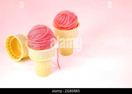 Rosa Garnkugeln in Eiszapfen isoliert auf rosa Hintergrund Stockfoto