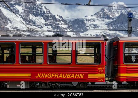 Jungfraubahn Iconic Red Train in kleine Scheidegg mit Schweizer Alpen Eiger Mountains im Hintergrund - Jungfrau Region, Schweiz Stockfoto