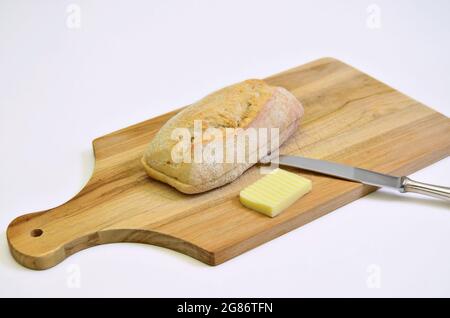 Brötchen und Butter auf Schneidebrett, Nahaufnahme, isoliert auf weißem Backbround Stockfoto