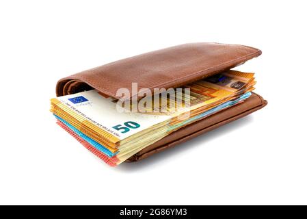 Braune Männer-Geldbörse aus Leder mit einem Stapel Euro-Banknoten im Inneren, isoliert auf weißem Hintergrund, 50 Euro sichtbar. Stockfoto