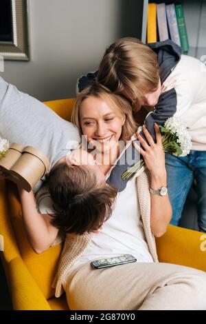 Nahaufnahme Porträt von zwei liebenden niedlichen kleinen Kindern Söhne umarmt küssen glücklich junge Mutter gratuliert zum Geburtstag. Stockfoto