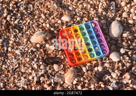 rainbow Pop IT Spielzeug zum Spielen im Urlaub am Meer. Stockfoto