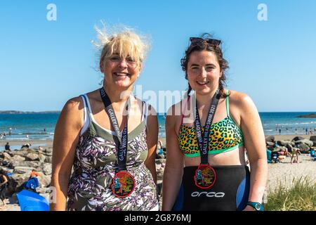 Rossarbery, West Cork, Irland. Juli 2021. Die Temperaturen erreichten heute in Rosscarbery 27 Grad, während der Warren Beach voller Sonnenanbeter war. Die Galey Head Schwimm fand heute statt, wo die Teilnehmer schwammen von Red Strand zum Warren Beach, eine Entfernung von 10 KM. Nach dem Schwimmen mit ihren Medaillen sind Hetty Walsh, Clonakilty und Jane O'Donovan, Ballineen, zu sehen. Quelle: AG News/Alamy Live News Stockfoto