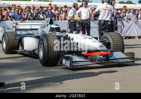 McLaren MP4/13 Formel 1, Grand-Prix-Rennwagen im Montagebereich beim Goodwood Festival of Speed 2013 vor dem Aufstieg auf die Schanze. Crew Stockfoto