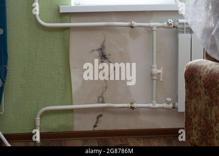 Riss in der Wand der Wohnung. Durch einen Riss in der Wand strömt Regenwasser in die Wohnung. Stockfoto