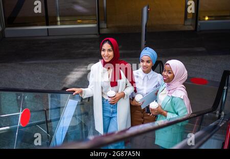 Multiethnische Gruppe muslimischer Mädchen in legerer Kleidung und traditionellem Hijab-Bonding und Spaß im Freien - 3 arabische junge Mädchen Stockfoto