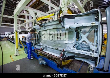 USt'-Kamenogorsk, Kasachstan - Mai 31,2012: Förderlinie der Asia-Auto-Firma für den Automobilbau. Drehen Sie die Karosserie mit einem speziellen Gerät, um zu arbeiten. Stockfoto