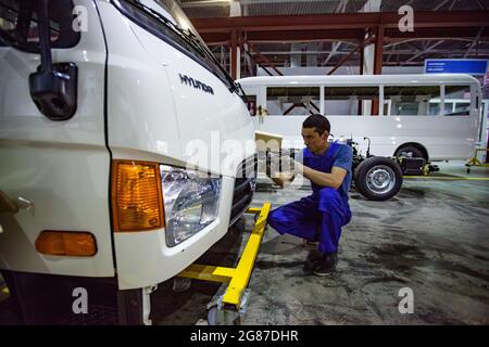 Almaty Region, Kasachstan-Juni 06, 2012:Astana-Motors Unternehmen Auto-Gebäude-Werk.Hyundai Busse Montage.Junge asiatische Arbeiter Installation von Kunststoffteilen. Stockfoto