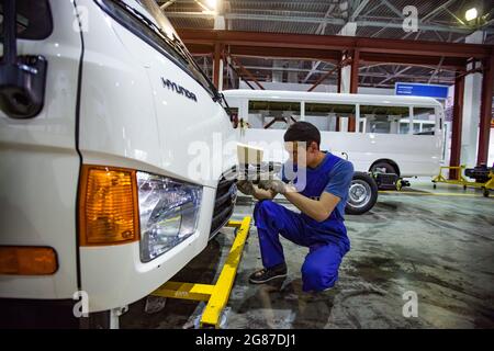 Almaty Region, Kasachstan-Juni 06, 2012:Astana-Motors Firma Auto-Building plant.Hyundai Busse Montage.Junge asiatische Arbeiter installieren Kunststoff-Heizkörper. Stockfoto