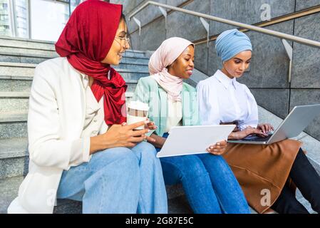 Multiethnische Gruppe muslimischer Mädchen in legerer Kleidung und traditionellem Hijab-Bonding und Spaß im Freien - 3 arabische junge Mädchen Stockfoto