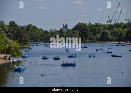 Am heißesten Tag des Jahres fahren die Leute mit den Tretbooten auf dem Serpentine Lake im Hyde Park. London, Großbritannien. Juli 2021. Stockfoto