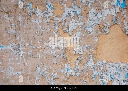 Altes Pinnwand. Eine alte Straßenplakatwand mit einer zerrissenen Plakatwand, die horizontal platziert wurde. Außenwerbung oder Sperrholzplatte mit abgenutzter Werbung Stockfoto