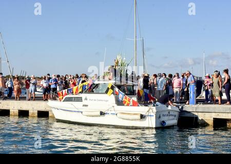 Ein Blick auf ein Boot, das mit einer Statue der Virgen del Carmen während der Seefahrt Prozession in Vendrell führt. Jedes Jahr am 16. Juli wird ein religiöses Fest zu Ehren der Virgen del Carmen, der schutzpatronin der Seefahrer und Fischer, gefeiert, obwohl die Feier am 16. Juli stattfindet, die Prozession am Wochenende stattfindet, damit mehr Menschen an der Feier teilnehmen können. Die Statue der Jungfrau, wird von einer Gruppe von Menschen, die es zu einem Boot verlassen während der Prozession durch das Wasser des Meeres in der Nähe des Hafens, gefolgt von mehreren Booten getragen. Stockfoto