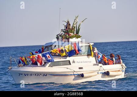 Ein Blick auf ein Boot, das mit einer Statue der Virgen del Carmen während der Seefahrt Prozession in Vendrell führt. Jedes Jahr am 16. Juli wird ein religiöses Fest zu Ehren der Virgen del Carmen, der schutzpatronin der Seefahrer und Fischer, gefeiert, obwohl die Feier am 16. Juli stattfindet, die Prozession am Wochenende stattfindet, damit mehr Menschen an der Feier teilnehmen können. Die Statue der Jungfrau, wird von einer Gruppe von Menschen, die es zu einem Boot verlassen während der Prozession durch das Wasser des Meeres in der Nähe des Hafens, gefolgt von mehreren Booten getragen. Stockfoto