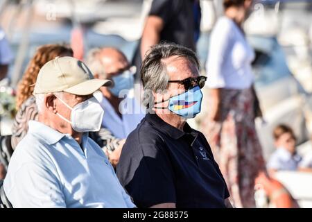 Josep Bou IB·'ez (rechts) Präsident des Hafens von Coma-ruga gesehen während der Seeprozession der Virgen del Carmen in Vendrell. Jedes Jahr am 16. Juli wird ein religiöses Fest zu Ehren der Virgen del Carmen, der schutzpatronin der Seefahrer und Fischer, gefeiert, obwohl die Feier am 16. Juli stattfindet, die Prozession am Wochenende stattfindet, damit mehr Menschen an der Feier teilnehmen können. Die Statue der Jungfrau, wird von einer Gruppe von Menschen, die es zu einem Boot verlassen während der Prozession durch das Wasser des Meeres in der Nähe des Hafens, gefolgt von mehreren Booten getragen. Stockfoto