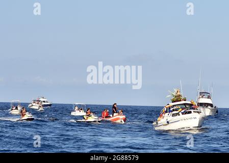 Ein Blick auf ein Boot, das mit einer Statue der Virgen del Carmen führt, gefolgt von mehreren Booten während der Seeprozession in Vendrell. Jedes Jahr am 16. Juli wird ein religiöses Fest zu Ehren der Virgen del Carmen, der schutzpatronin der Seefahrer und Fischer, gefeiert, obwohl die Feier am 16. Juli stattfindet, die Prozession am Wochenende stattfindet, damit mehr Menschen an der Feier teilnehmen können. Die Statue der Jungfrau, wird von einer Gruppe von Menschen, die es zu einem Boot verlassen während der Prozession durch das Wasser des Meeres in der Nähe des Hafens, gefolgt von mehreren Booten getragen. Stockfoto