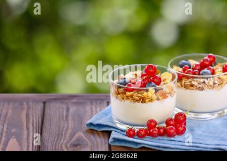 Müsli mit griechischem Joghurt und Beeren in zwei Gläsern Stockfoto