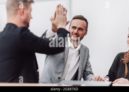 Junge Mitarbeiter geben einen hohen fünf Stockfoto