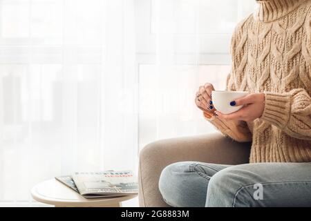 Junge Frau trinkt Kaffee zu Hause Stockfoto