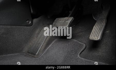Man Fuß und Gaspedal und Bremspedal im Auto oder Fahrzeug und kopieren Raum, die schwarze Farbe Lederschuh trat auf sie für Geschwindigkeit oder Kontrolle Stockfoto