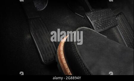 Man Fuß und Gaspedal und Bremspedal im Auto oder Fahrzeug und kopieren Raum, die schwarze Farbe Lederschuh trat auf sie für Geschwindigkeit oder Kontrolle Stockfoto