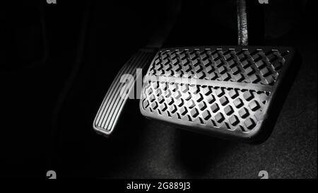 Man Fuß und Gaspedal und Bremspedal im Auto oder Fahrzeug und kopieren Raum, die schwarze Farbe Lederschuh trat auf sie für Geschwindigkeit oder Kontrolle Stockfoto