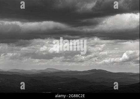 Nordblick vom Mt. Kearsarge Gipfel in Richtung Cardigan und Smarts Mountain. Entfernte Gipfel und Grate. Gewitterwolken. Schwarzweiß-Querformat Stockfoto