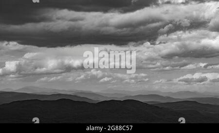 Nordblick vom Mt. Kearsarge Gipfel in Richtung Ragged Mountain. Weit entfernte Gipfel und Grate der White Mountains. Gewitterwolken. Schwarzweiß-Querformat. Stockfoto