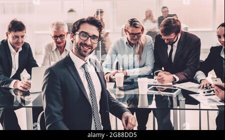 Selbstbewusster Geschäftsmann, der in der Nähe des Büroschreibens sitzt. Stockfoto