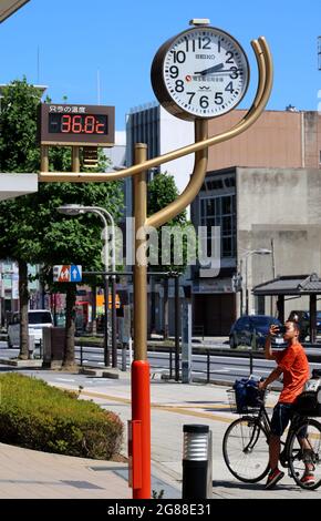 Kumagaya, Japan. Juli 2021. Am Sonntag, den 18. Juli 2021, fotografiert ein Radfahrer ein Thermometer, das in Kumagaya, einem Vorort von Tokio, eine Temperatur von 36.0 Grad Celsius anzeigt. Die Temperaturen im Großraum Tokio stiegen nach Abschluss der Regenzeit in die Höhe. Quelle: Yoshio Tsunoda/AFLO/Alamy Live News Stockfoto