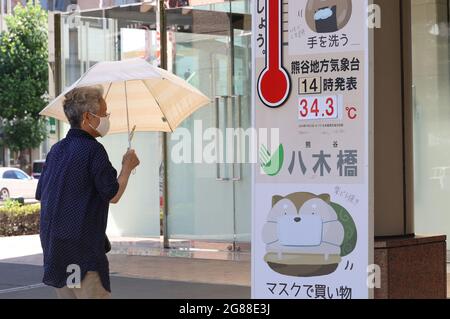 Kumagaya, Japan. Juli 2021. Ein Einkäufer tritt in ein Kaufhaus ein, während das Kaufhaus am Sonntag, den 18. Juli 2021, in Kumagaya, einem Vorort von Tokio, eine Temperatur anzeigt. Die Temperaturen im Großraum Tokio stiegen nach Abschluss der Regenzeit in die Höhe. Quelle: Yoshio Tsunoda/AFLO/Alamy Live News Stockfoto