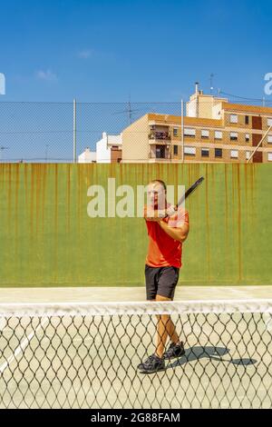 Der junge Mann trainierte auf einem betonierten Tennisplatz, um sein Tennisspiel zu verbessern und sein Ziel beim ATP zu erreichen. Traumkonzept Stockfoto