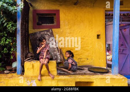 Badami, Karnataka, Indien - 10. Januar 2020 : zwei kleine Mädchen vor dem gelben Wandhaus in Badami, Karnataka, Indien Stockfoto