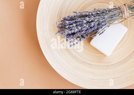 Handgemachte Lavendelseife. Stück Naturseife mit getrockneten Lavendelblüten auf Bambusplatte mit Kopierraum. Bio-Kosmetik für Hautpflege und Spa. Stockfoto