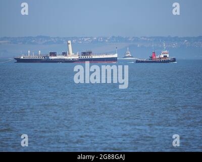 Sheerness, Kent, Großbritannien. Juli 2021. Der historische Raddampfer „Medway Queen“ wurde heute früh auf dem Weg nach Ramsgate an Sheerness, Kent vorbeigeschleppt. Das Schiff, das gerade restauriert wird, stammt aus dem Jahr 1923 und wurde 1940 als "Heldin von Dünkirchen" bekannt, nachdem es bei der Evakuierung britischer Truppen aus der Normandie geholfen hatte. (Südküste im Hintergrund). Kredit: James Bell/Alamy Live Nachrichten Stockfoto