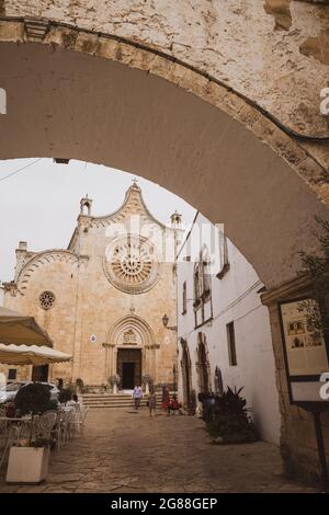Kathedrale der Heiligen Maria von der Himmelfahrt mit einem Platz und Café voller Menschen. Kirche der mittelalterlichen weißen Stadt Ostuni Provinz Brindisi Stockfoto