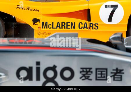 Der McLaren M8F kann auf dem Goodwood Festival of Speed 2013 von Fahrer Peter Revson ein Rennauto mit Kiwi-Symbol auf einem orangefarbenen Auto fahren. Stockfoto