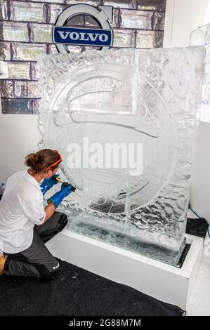 Person, die beim Goodwood Festival of Speed 2013 ein Volvo-Markenabzeichen in eine Eisskulptur schnitzt. Eis zum Meißeln, um Werbekunststücke zu Formen Stockfoto