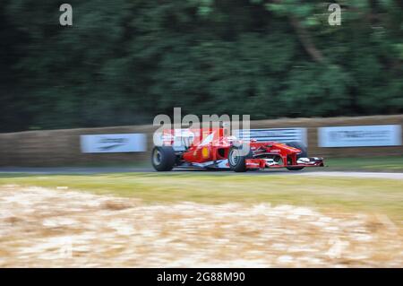 Ferrari F10 Formel 1, Grand-Prix-Rennwagen beim Goodwood Festival of Speed 2013, der mit hoher Geschwindigkeit auf der Bergrennstrecke unterwegs ist. Waldstück Stockfoto