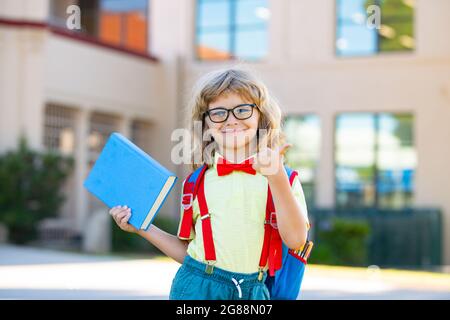 Konzept der Kindererziehung und des Lesens. Nette Kinder in der Nähe der Schule im Freien. Erster Schultag. Stockfoto