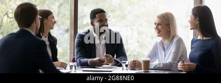 Ein glückliches, verschiedenes, gealtertes Geschäftsteam diskutiert über die Arbeit Stockfoto
