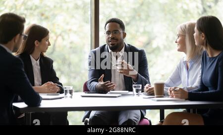 Motivierter afroamerikanischer Geschäftsleiter im Gespräch mit dem Team Stockfoto