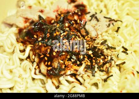 Gekochte trockene Instant-Nudeln, die würzige koreanische Sauce auf einer Schüssel anrichten Stockfoto