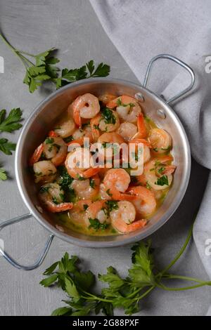 Shrimp Scampi mit Knoblauch und Buttersauce bestreut mit Petersilie, auf einer Pfanne. Keto Diätgericht Stockfoto