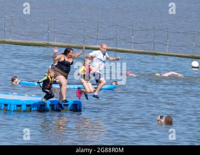 Clevedon, Somerset, Großbritannien. Juli 2021. Spaß für die ganze Familie. Der Clevedon Marine Lake zieht Menschen an, die an einem sehr heißen Tag abkühlen möchten. Paddle-Boarding, Einspringen und Schwimmen stehen vor dem morgigen Tag der Freiheit auf dem Programm für Familienspaß. Kredit: JMF Nachrichten/Alamy Live Nachrichten Stockfoto