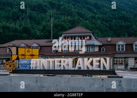Bahnhof Interlaken Ost (Interlaken Zollhaus) mit grünem Berg dahinter - Schweizer Alpen, Schweiz Stockfoto