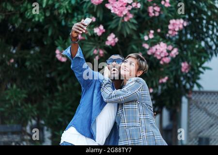 Glückliche Momente. Fröhliches schwarzes Paar, das Selfie auf dem Smartphone macht, während es romantische Date-Reisen macht, afroamerikanische Ehegatten mittleren Alters auf Reise. Gemischt Stockfoto