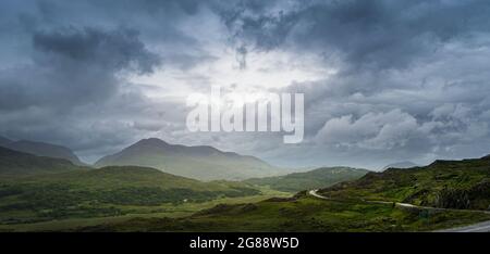 Panoramablick auf die irische Landschaft von Ladies View im Killarney National Park, mit einem Himmel mit sehr dichten Wolken. Stockfoto